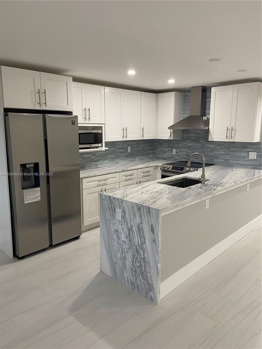1058 Guildford East, Unit 1058 Boca Raton, FL 33434 - Photo 1 of 14 a kitchen with stainless steel appliances granite countertop a refrigerator a stove a sink and a refrigerator