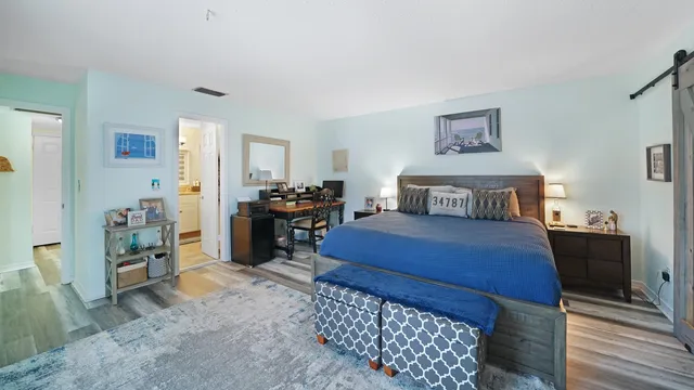 a bedroom with a bed and wooden floor