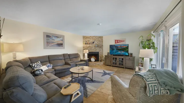 a living room with furniture a flat screen tv and a fireplace