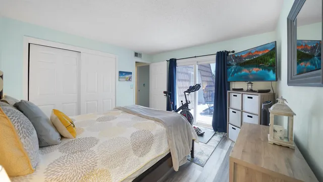 a bedroom with a large bed and a flat tv screen on dresser