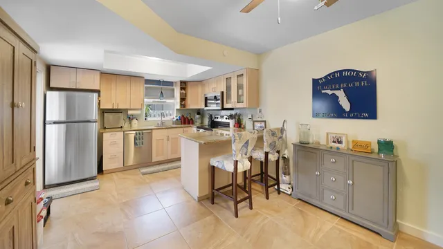a kitchen with a sink a refrigerator and chairs