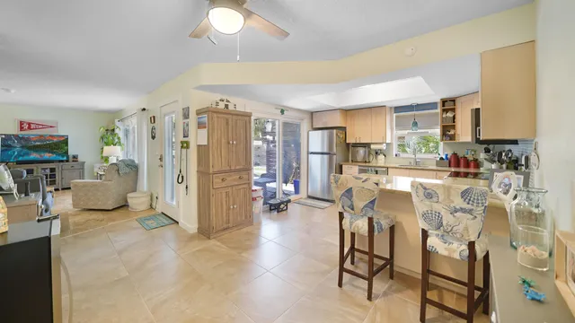 a living room with furniture a flat screen tv and a kitchen view