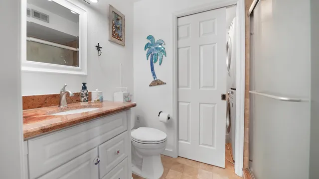 a bathroom with a granite countertop sink a toilet and a shower