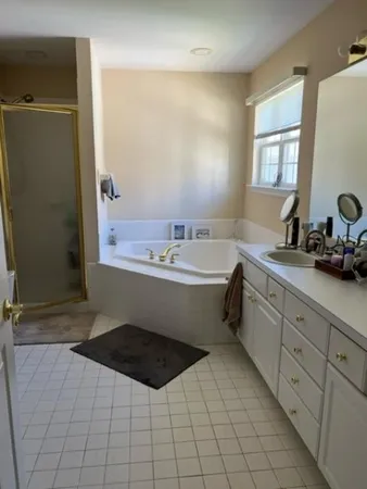a bathroom with a bathtub sink vanity mirror and toilet