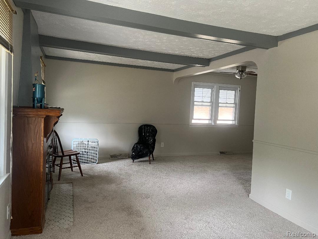 149 Roth Boulevard Clawson, MI 48017 - Photo 3 of 20 Spacious recreation room with exposed beam ceiling detail, neutral wall finishes, and abundant natural light from dual casement windows