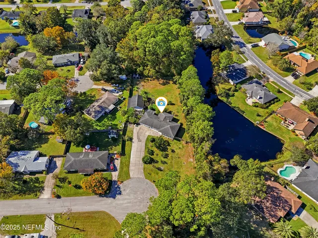 a view of house with large tree and a yard
