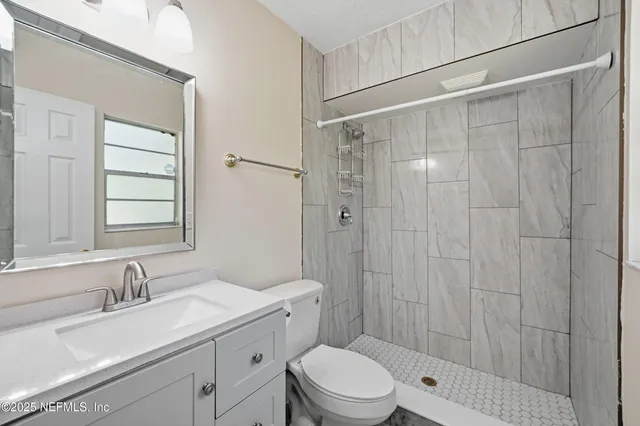 an empty room with a window and a ceiling fan