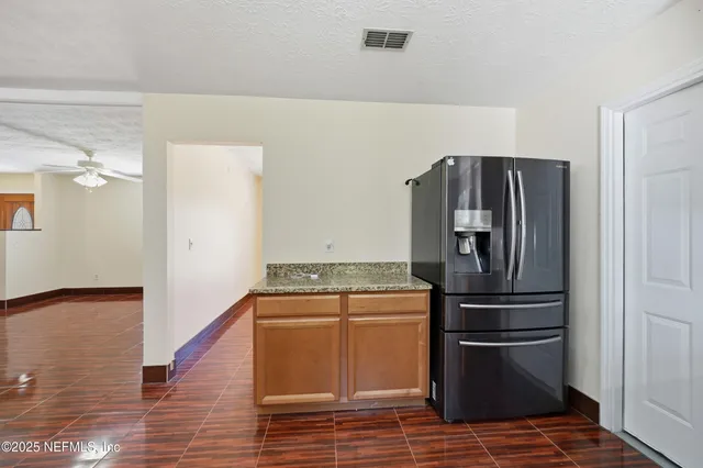 a kitchen with granite countertop a sink and cabinets