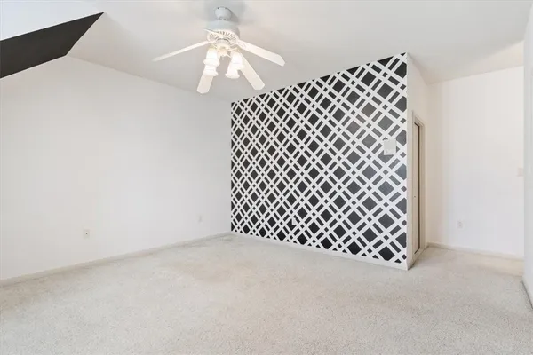 a view of an empty room with a chandelier fan