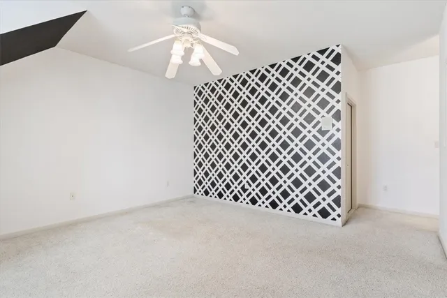 a view of an empty room with a chandelier fan