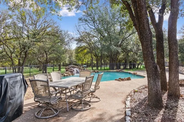 a view of a swimming pool with a patio and a yard