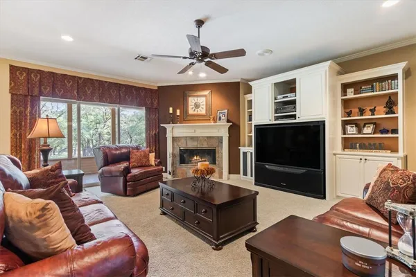 a living room with furniture a large window and a fireplace