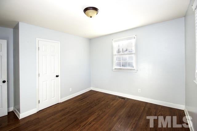 1212 North King Charles Road Raleigh, NC 27610 - Photo 12 of 16 an empty room with wooden floor and windows