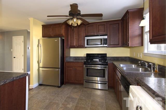 1212 North King Charles Road Raleigh, NC 27610 - Photo 8 of 16 a kitchen with a refrigerator and a sink