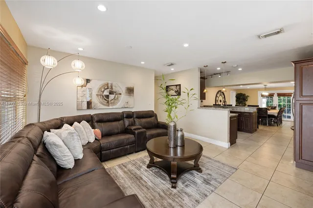 a living room with furniture and view of kitchen