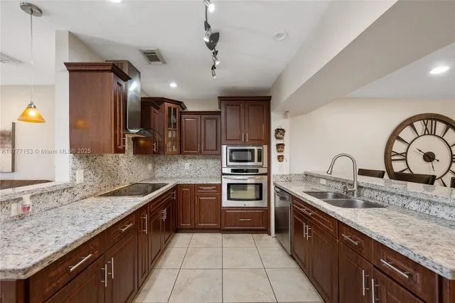 a kitchen with stainless steel appliances granite countertop a sink stove and cabinets