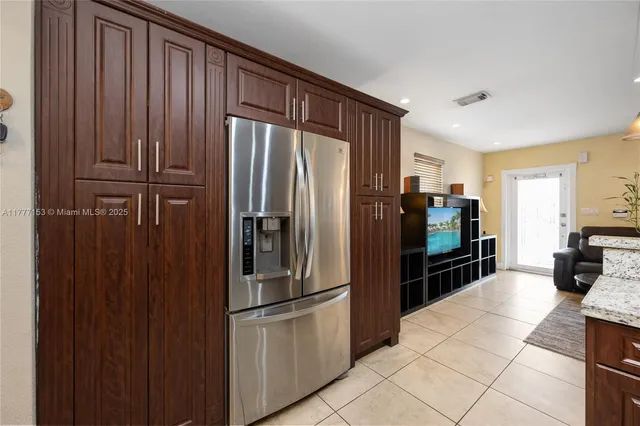 a kitchen with granite countertop a refrigerator and a sink