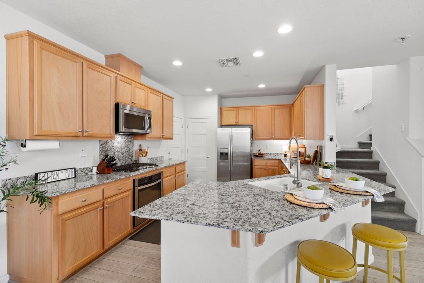 94 Caspian Way Gilroy, CA 95020 - Photo 12 of 40 a kitchen with stainless steel appliances granite countertop a sink dishwasher stove top oven with granite countertops and cabinets