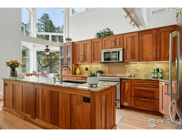 a kitchen with stainless steel appliances wooden cabinets a stove a sink and a microwave