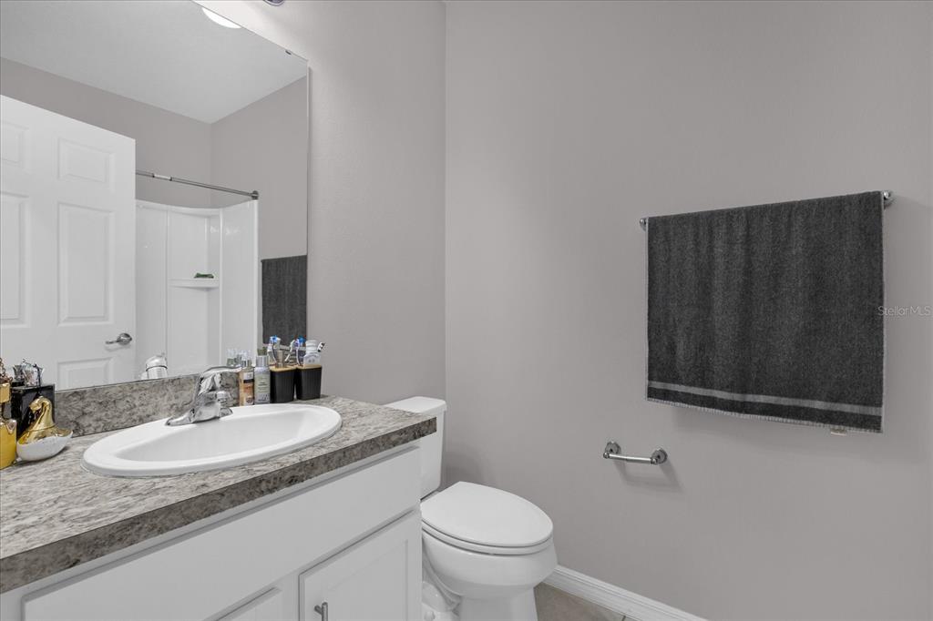 3470 Beau Road Kissimmee, FL 34746 - Photo 21 of 40 a bathroom with a granite countertop sink and a toilet