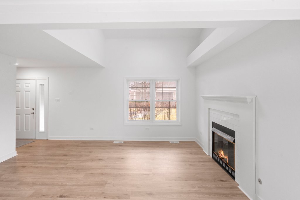 7050 Olde Gatehouse Road Tinley Park, IL 60477 - Photo 11 of 37 a view of an empty room with wooden floor fireplace and a window