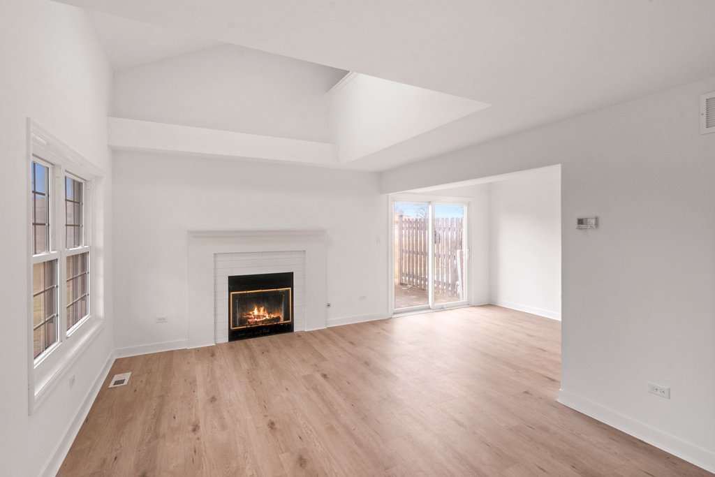 7050 Olde Gatehouse Road Tinley Park, IL 60477 - Photo 10 of 37 an empty room with wooden floor fireplace and windows