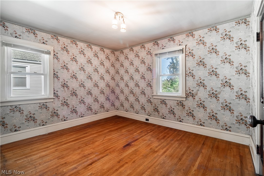 3839 Silsby Road Cleveland, OH 44111 - Photo 17 of 34 Another bedroom with wood floors, vintage wallpaper, and a generous closet.