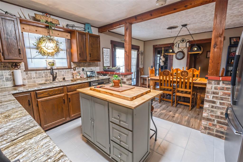978 Longbranch Road Nocona, TX 76255 - Photo 13 of 40 a kitchen with a sink and a refrigerator