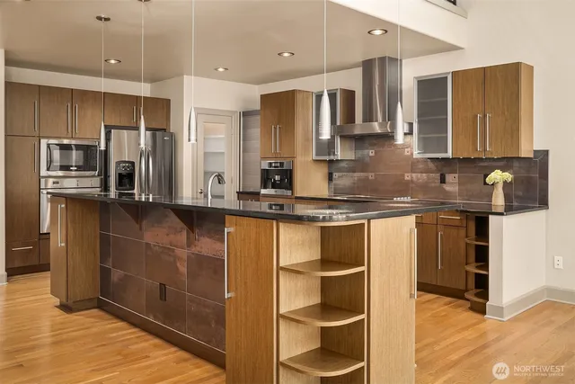 a kitchen with stainless steel appliances granite countertop a sink and a refrigerator