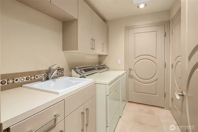 a utility room with sink dryer and washer