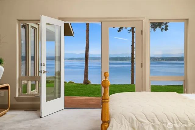 a bedroom with a bed and a large window