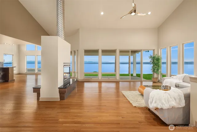 a spacious bedroom with a large window and a wooden floor