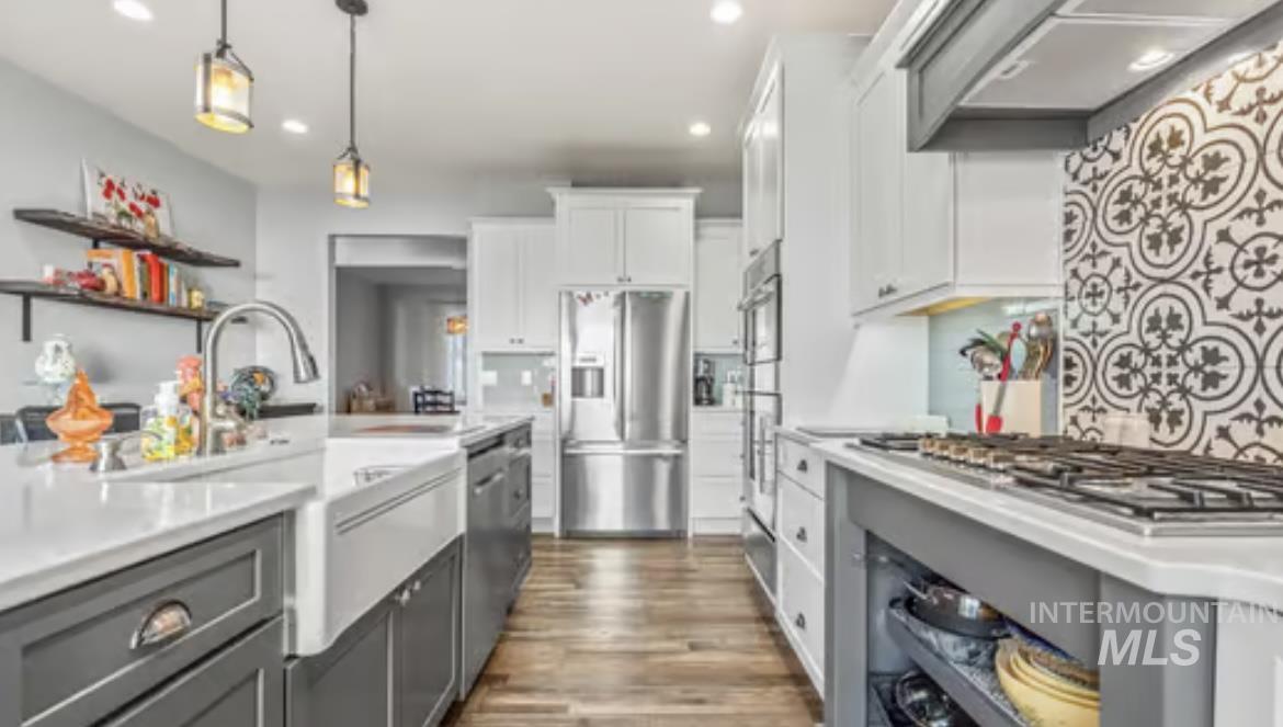16353 Brunello Court Caldwell, ID 83607 - Photo 13 of 45 Kitchen featuring gray cabinetry, white cabinets, custom exhaust hood, appliances with stainless steel finishes, and dark wood-style flooring