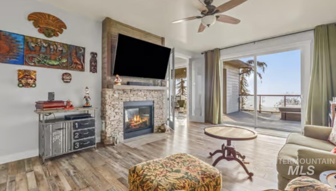 16353 Brunello Court Caldwell, ID 83607 - Photo 16 of 34 Living room with ceiling fan, wood finished floors, and a stone fireplace