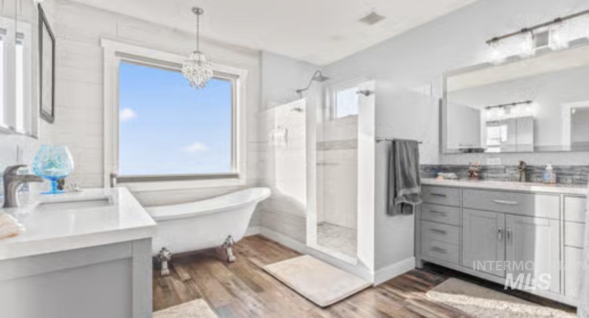 16353 Brunello Court Caldwell, ID 83607 - Photo 21 of 45 Full bath featuring vanity, light wood finished floors, a shower stall, a freestanding bath, and a chandelier