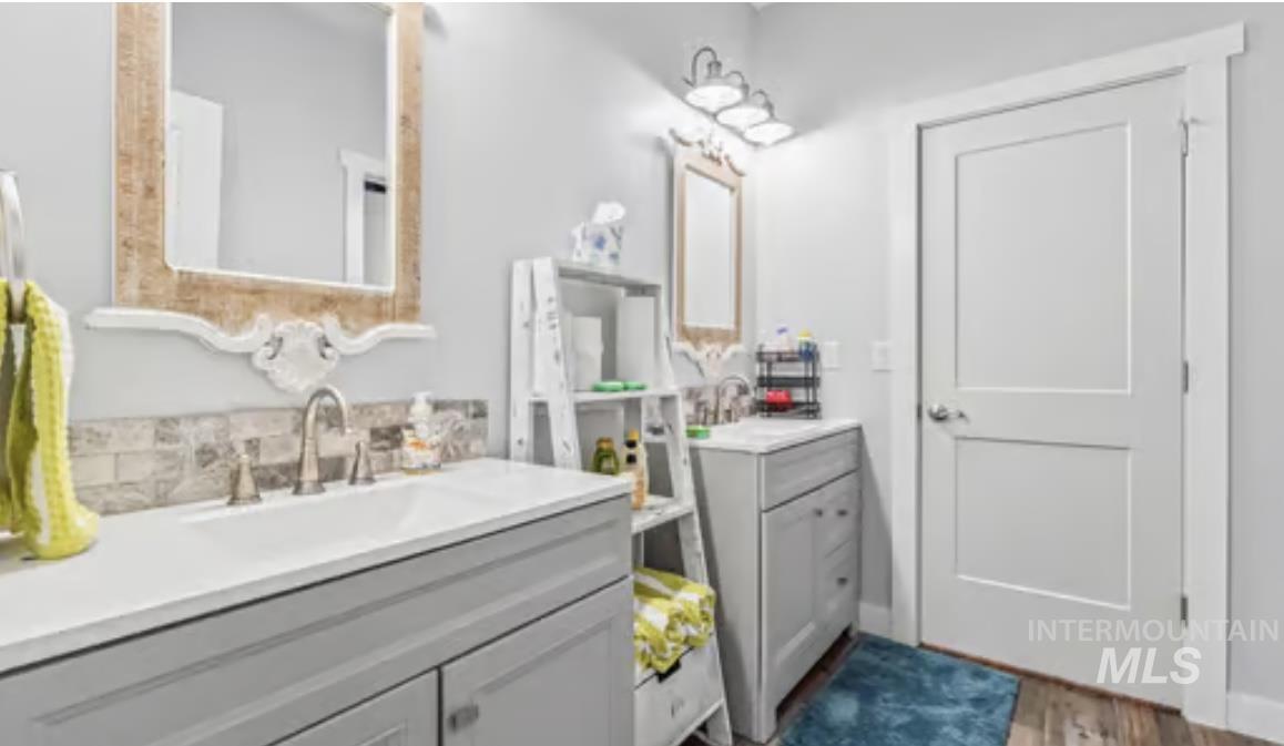 16353 Brunello Court Caldwell, ID 83607 - Photo 27 of 45 Full bathroom with two vanities and dark wood-style floors