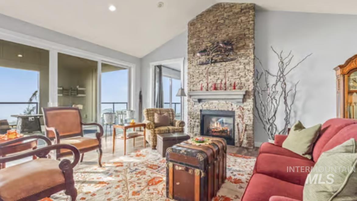16353 Brunello Court Caldwell, ID 83607 - Photo 7 of 45 Living area featuring lofted ceiling, a stone fireplace, and recessed lighting