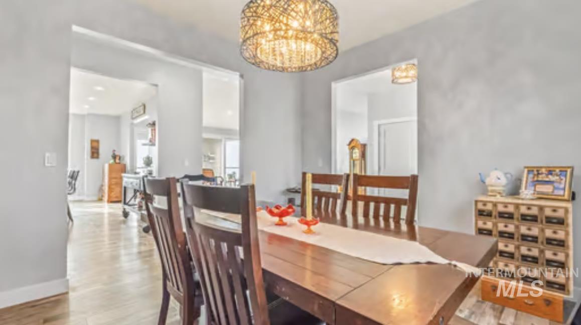 16353 Brunello Court Caldwell, ID 83607 - Photo 8 of 34 Dining space featuring light wood-type flooring and a chandelier