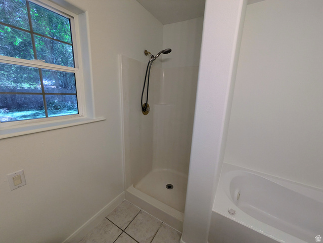 441 Main Street Hurricane, UT 84737 - Photo 14 of 29 White paneled shower stall with a brushed nickel shower head, separate soaking tub, and a window with exterior visibility