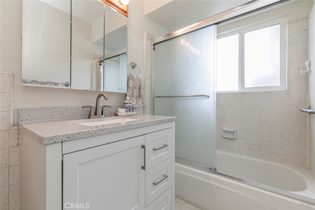 13166 Aztec Street Sylmar, CA 91342 - Photo 19 of 48 a bathroom with a granite countertop sink mirror vanity and a bathtub