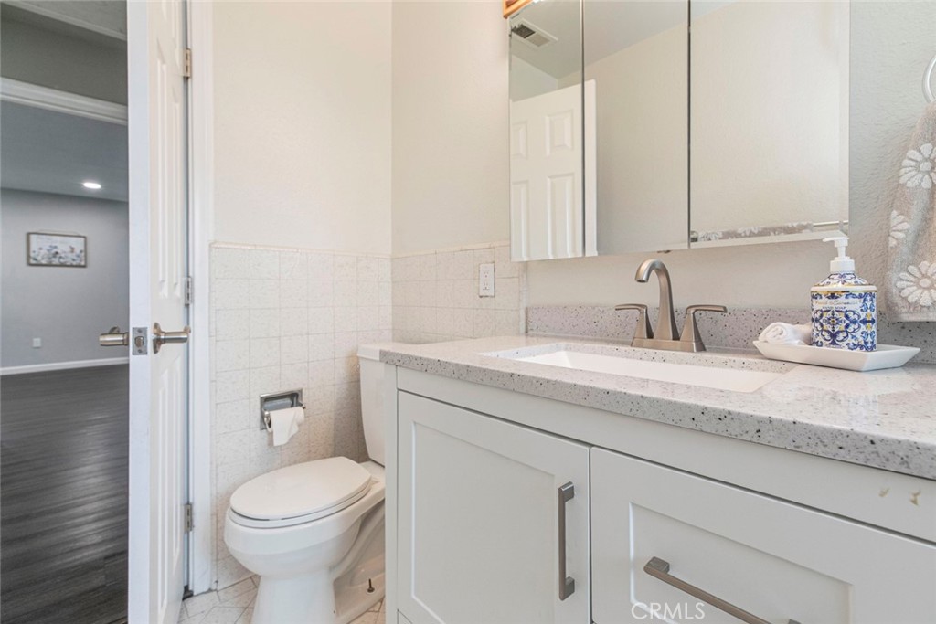 13166 Aztec Street Sylmar, CA 91342 - Photo 20 of 48 a bathroom with a granite countertop toilet sink and mirror