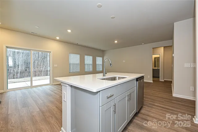 a kitchen with a sink and wooden floor