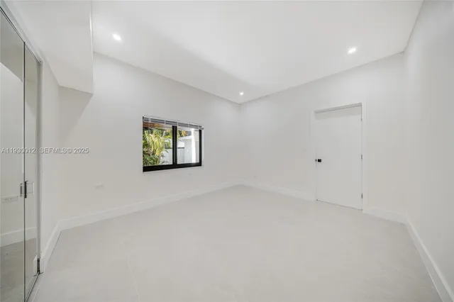 an empty room with a ceiling fan and windows