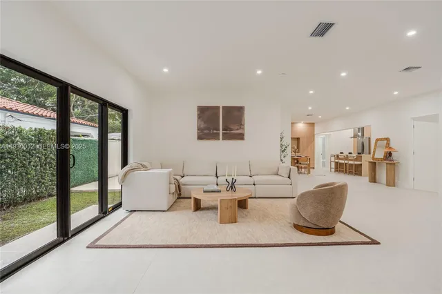 a living room with furniture a large window and a chandelier