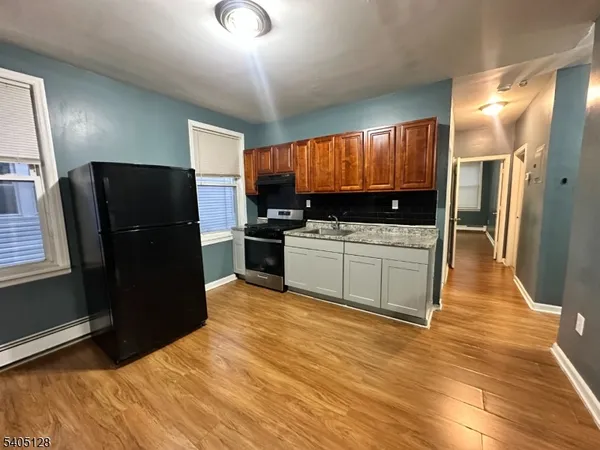 a kitchen with granite countertop a refrigerator and a sink
