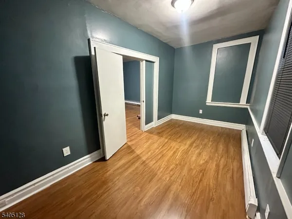 a view of an empty room with wooden floor