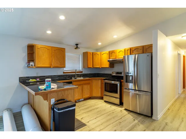 a kitchen with granite countertop a refrigerator and microwave