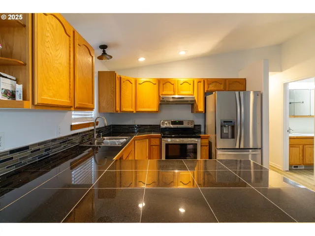 a kitchen with stainless steel appliances a stove a sink and a refrigerator