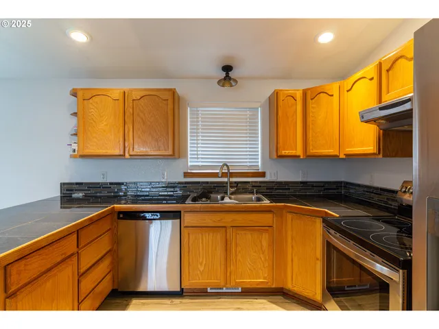 a kitchen with granite countertop wooden cabinets and a stove