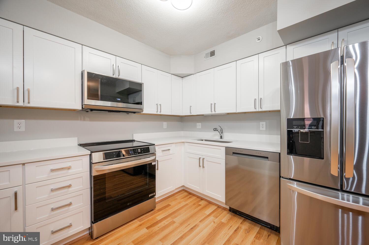 5000 Battery Lane, Unit 207 Bethesda, MD 20814 - Photo 2 of 34 a kitchen with cabinets stainless steel appliances and wooden floor